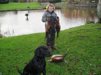 Kristian for the first time with pheasants in his hands. In the foreground my young dog Sydney who of course had picked up the birds.